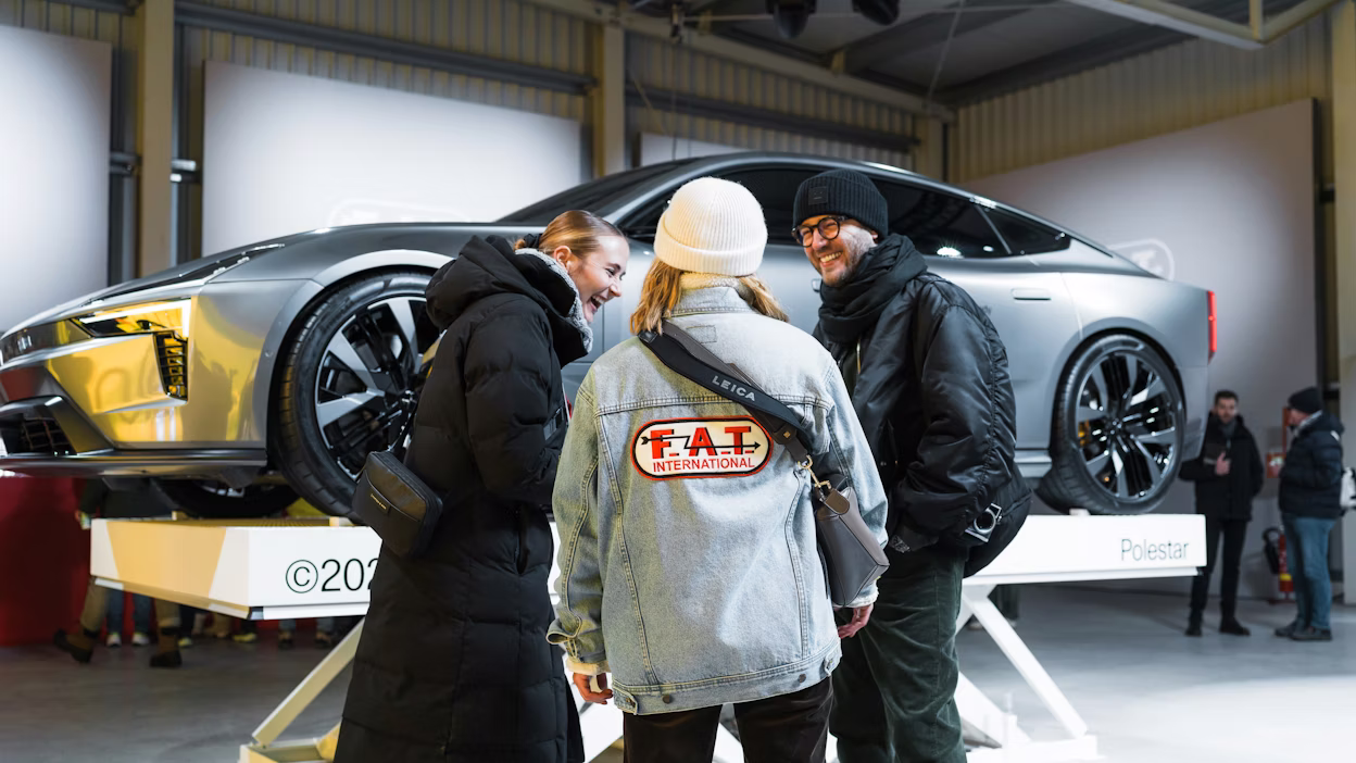 Attendees stand in front of raised Polestar 5