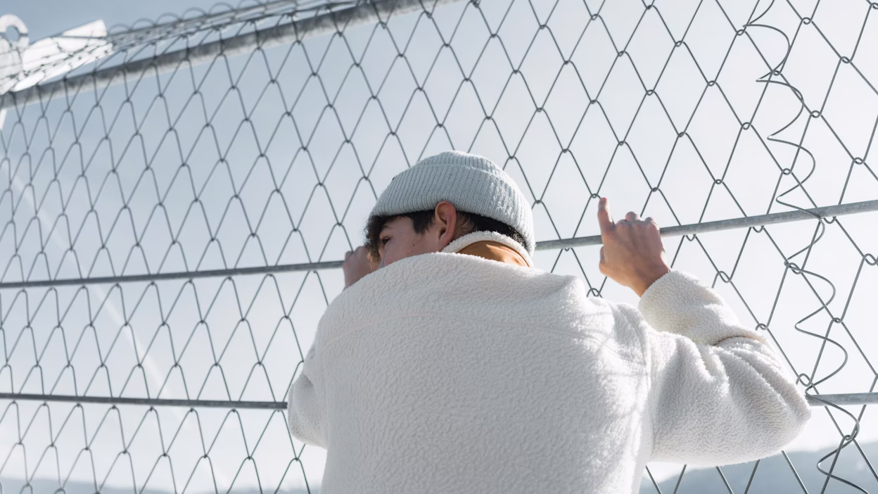 Spectator watching event behind safety fence