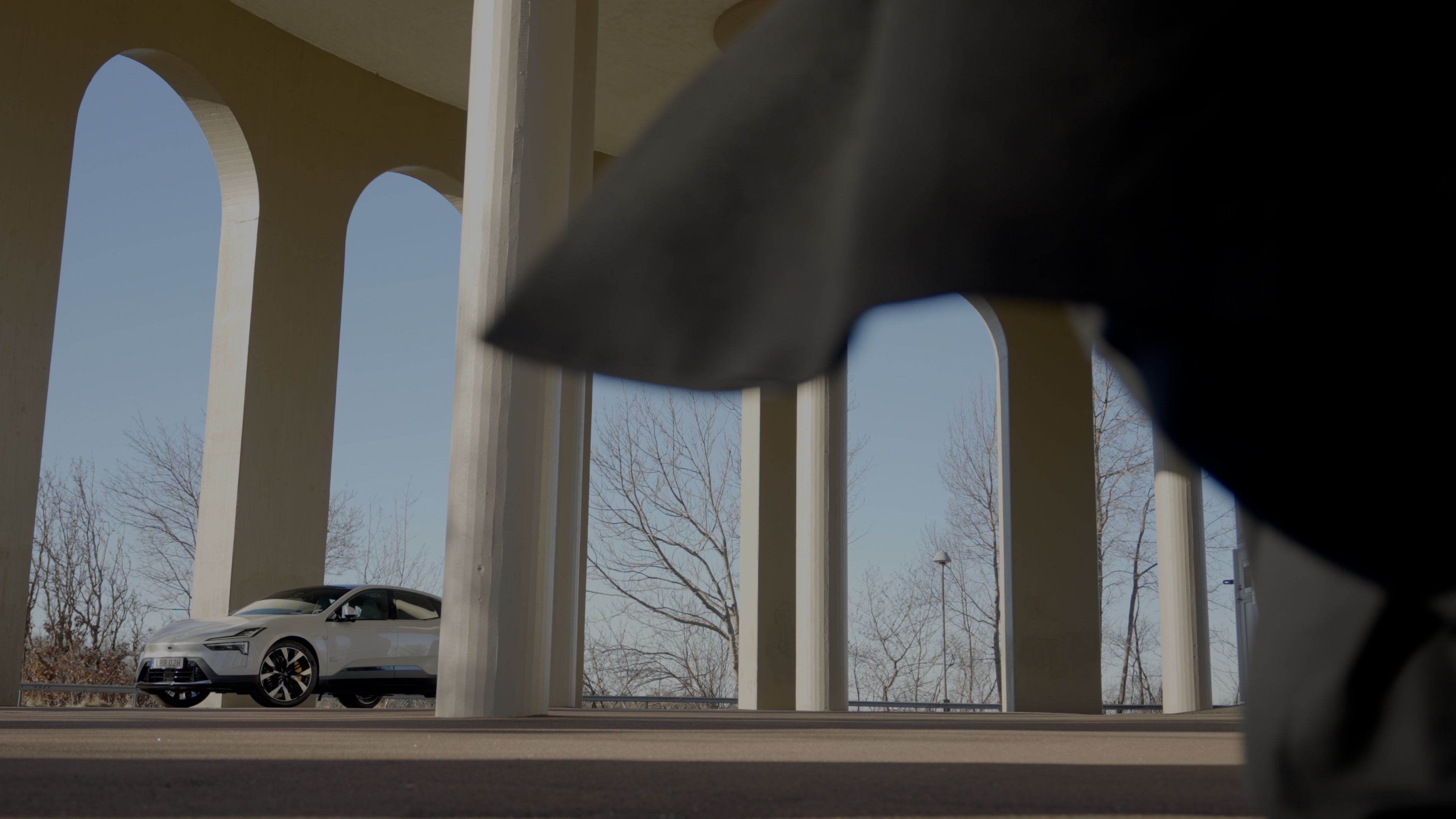 Man walking towards Polestar 4 under arches