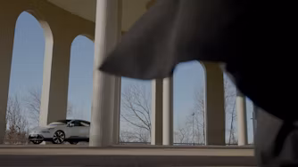 Man walking towards Polestar 4 under arches