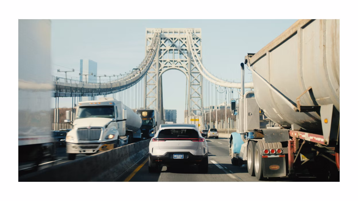 Achteraanzicht van de Polestar 3 die over een brug rijdt.