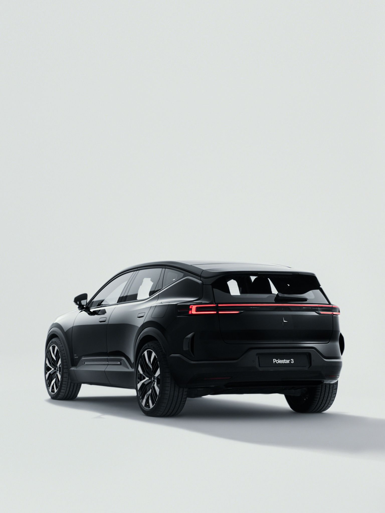 Black Polestar 3 rear side view grey studio background and long shadow