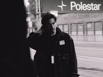 Milan Gino staat aan de zijkant van het circuit met Polestar-banner op de achtergrond.