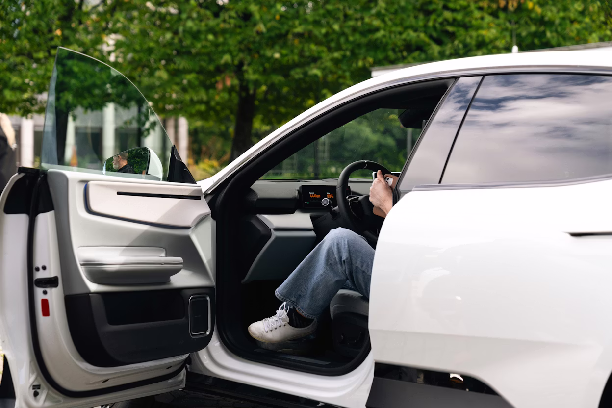 Vit Polestar 4 med besökare på väg ut från främre dörren