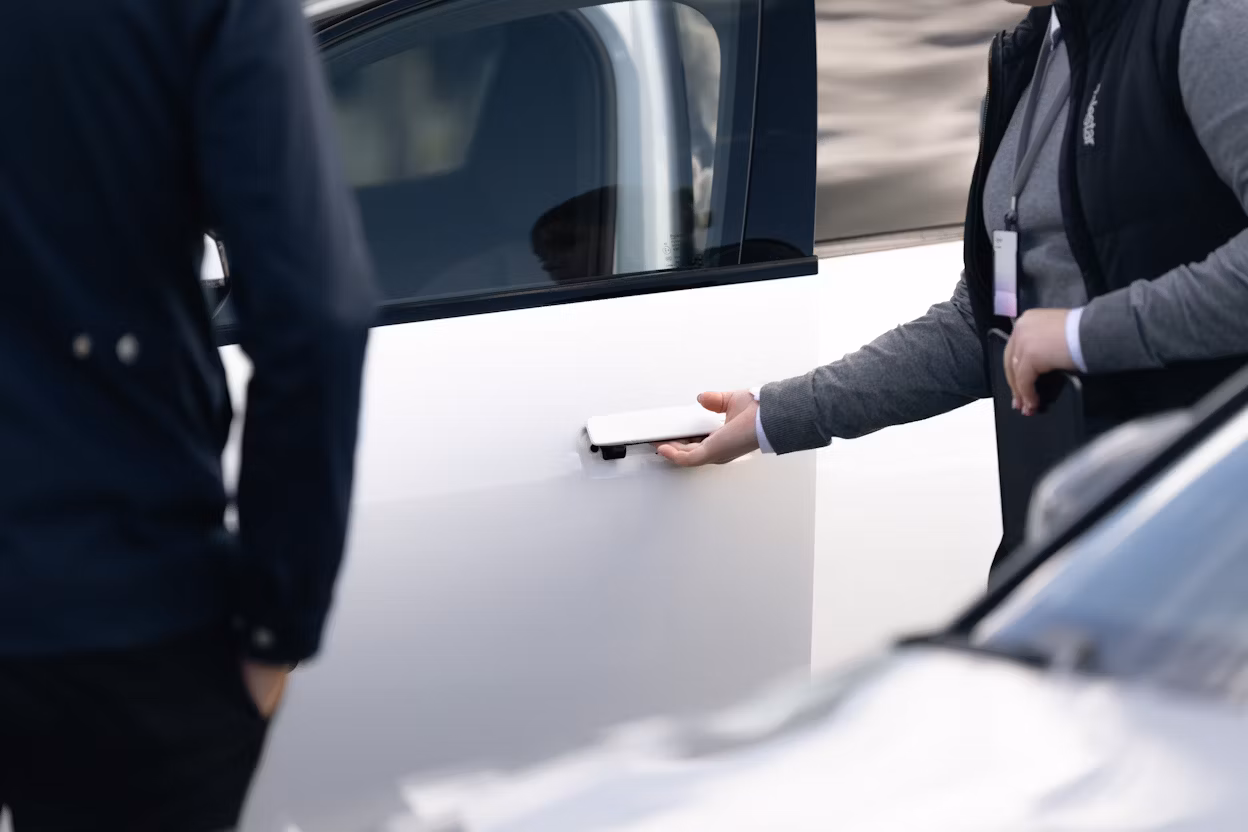 Specialist öppnar dörren på en vit Polestar