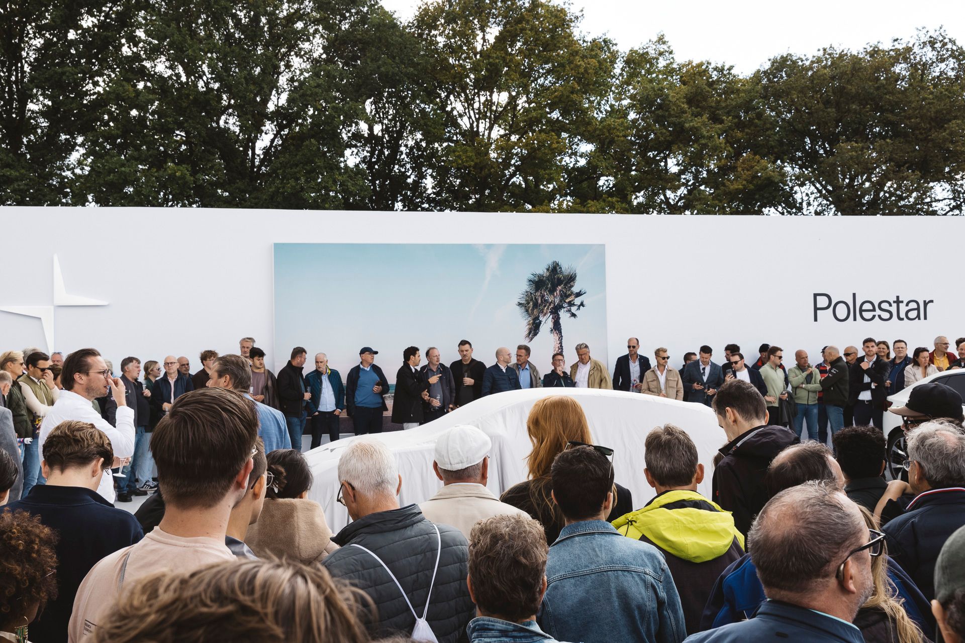 Tientallen mensen staan rond de Polestar 5 te wachten op de onthulling.