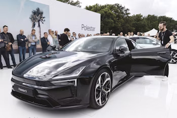 Polestar 5 staat op een wit platform met mensen eromheen.