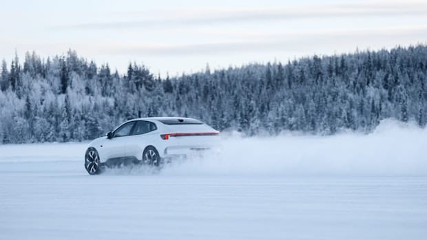 White Poletar 4 driving with snow whirling around and trees in the background