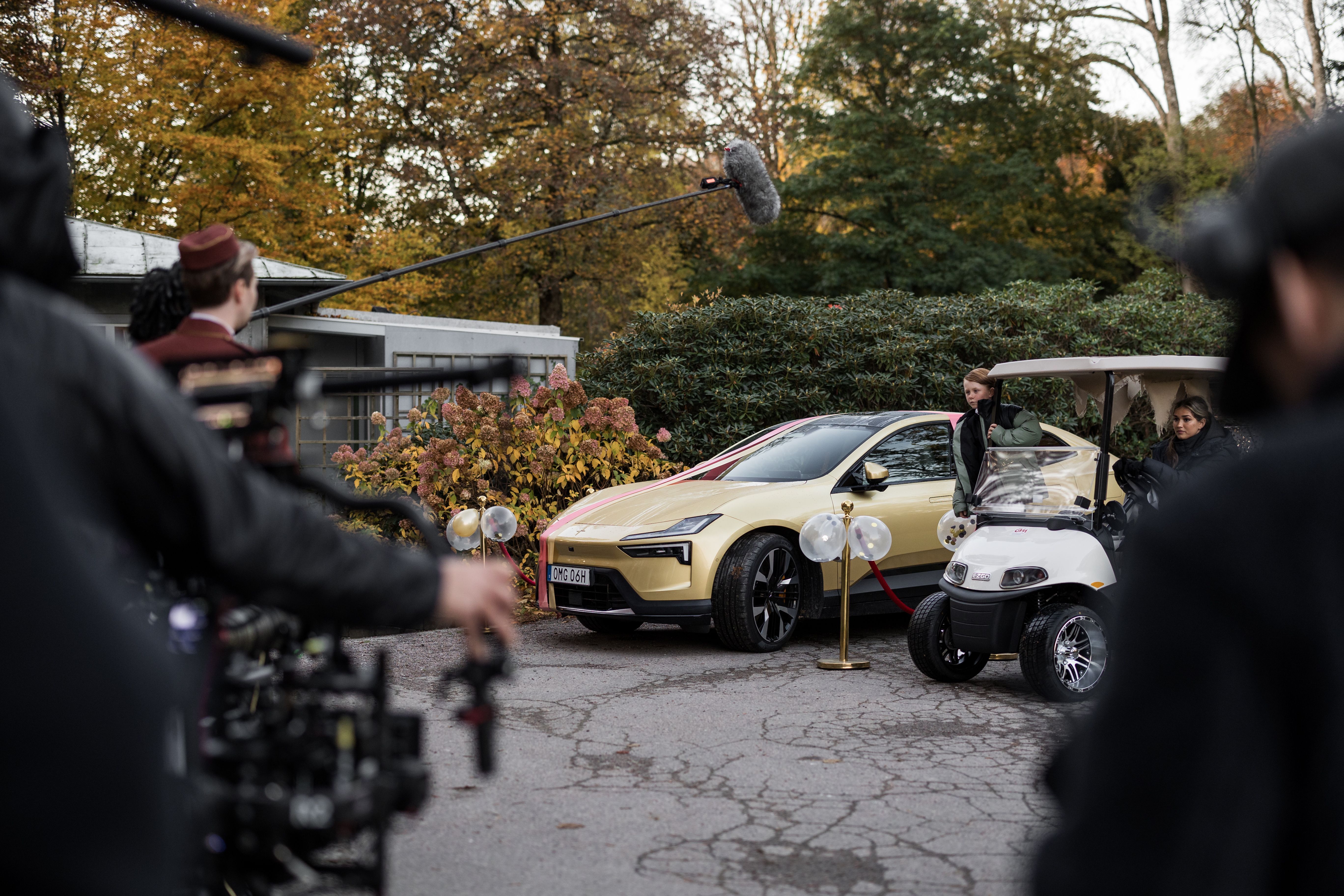 Behind the scenes shot of movie recording with a golden Polestar 4 and cameras