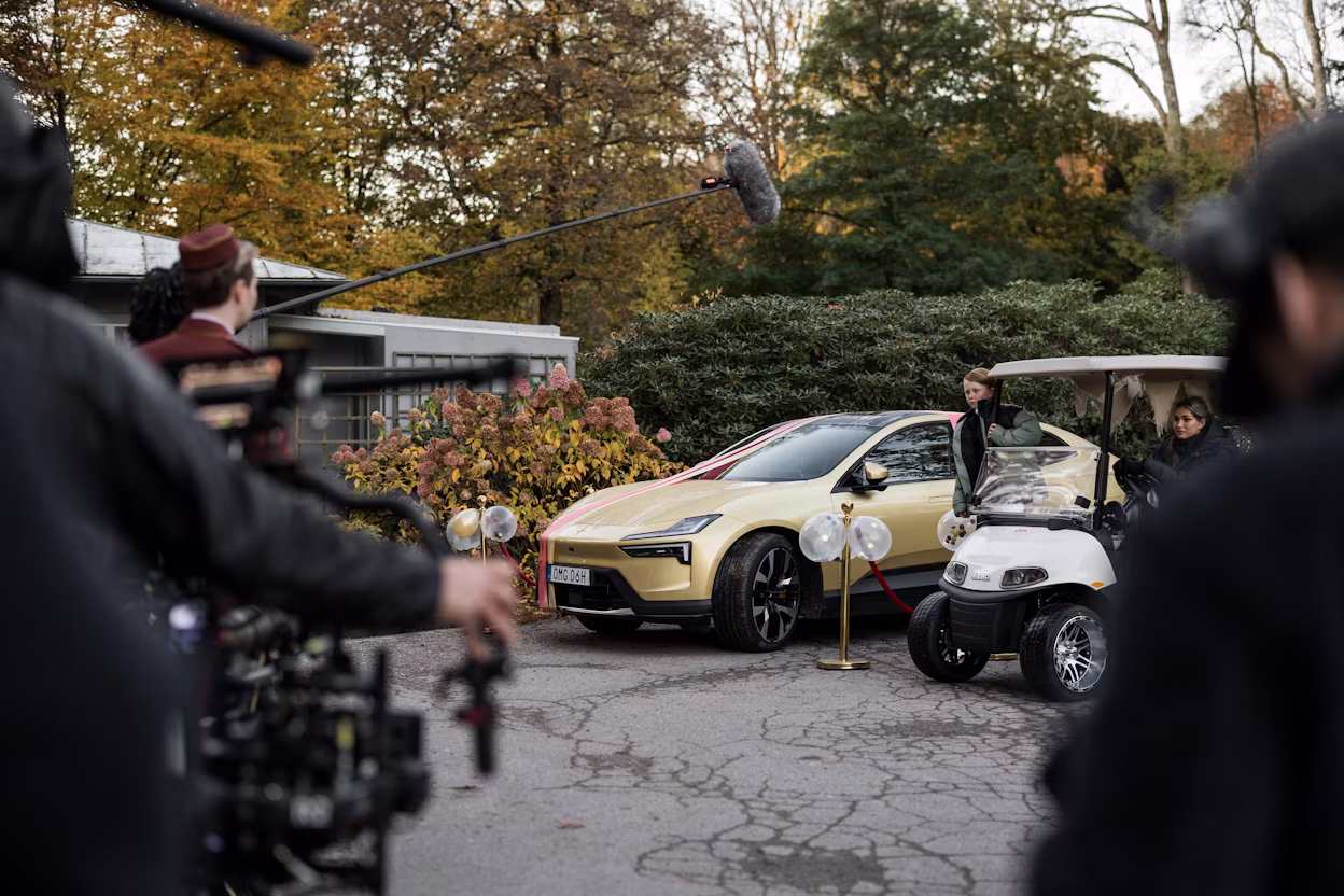 Behind the scenes shot of movie recording with a golden Polestar 4 and cameras