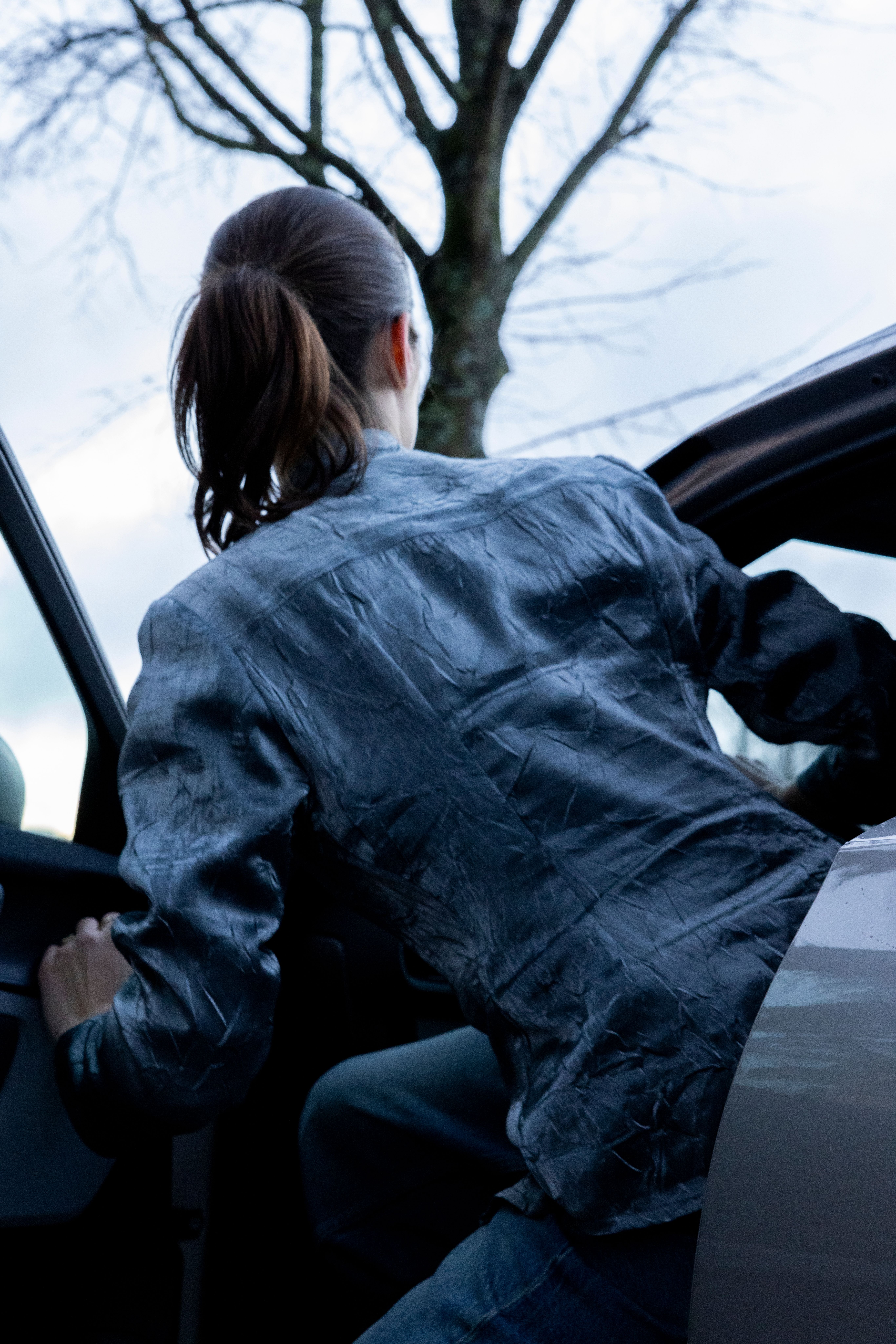 Achteraanzicht van Kiki Boreel die instapt in de Polestar 2.