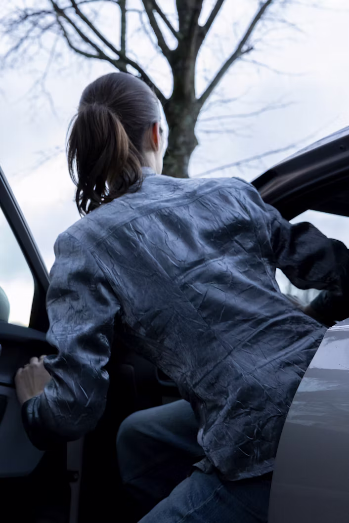 Achteraanzicht van Kiki Boreel die instapt in de Polestar 2.