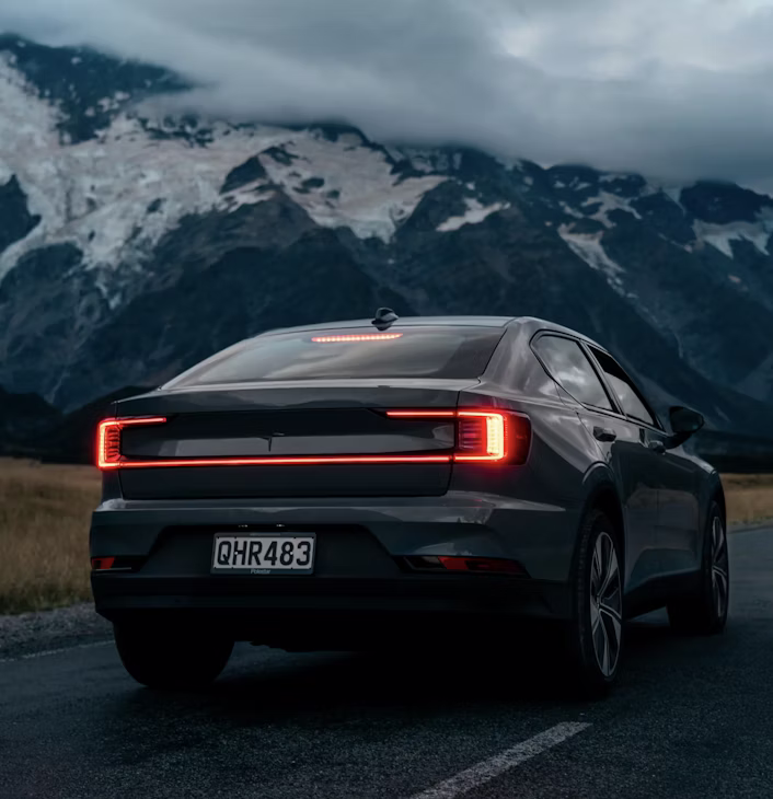 Polestar 2 rijdt op de weg in een berglandschap.