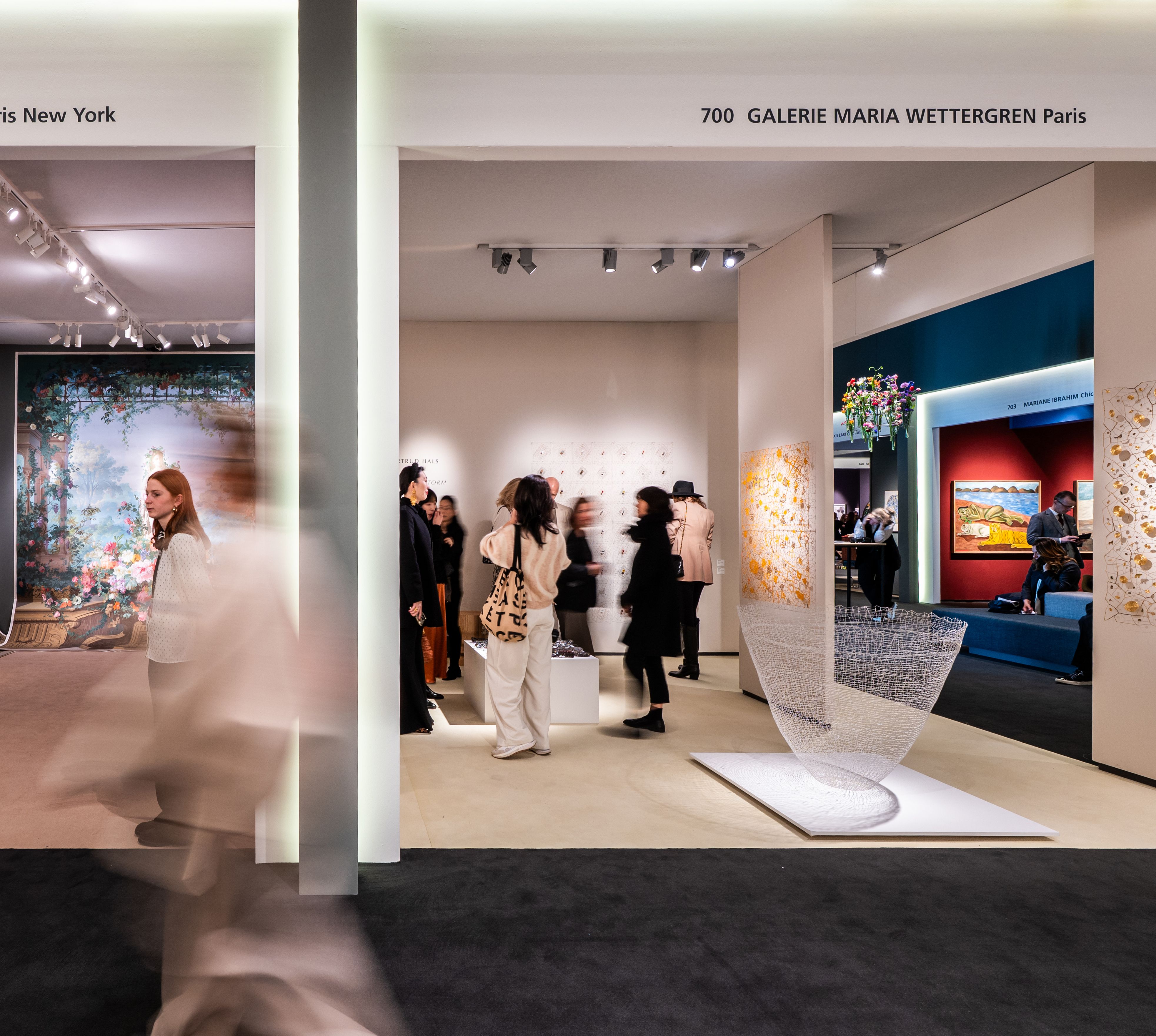 Mensen bekijken kunst op de beurs.