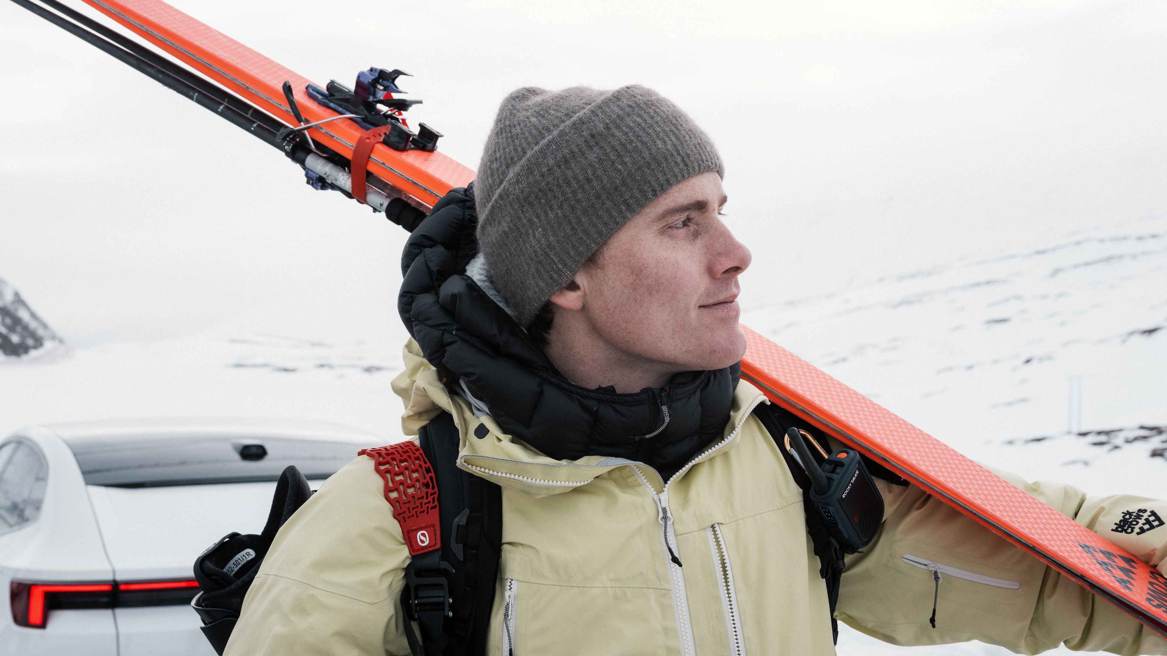 Profile of male skier in front of Polestar 4