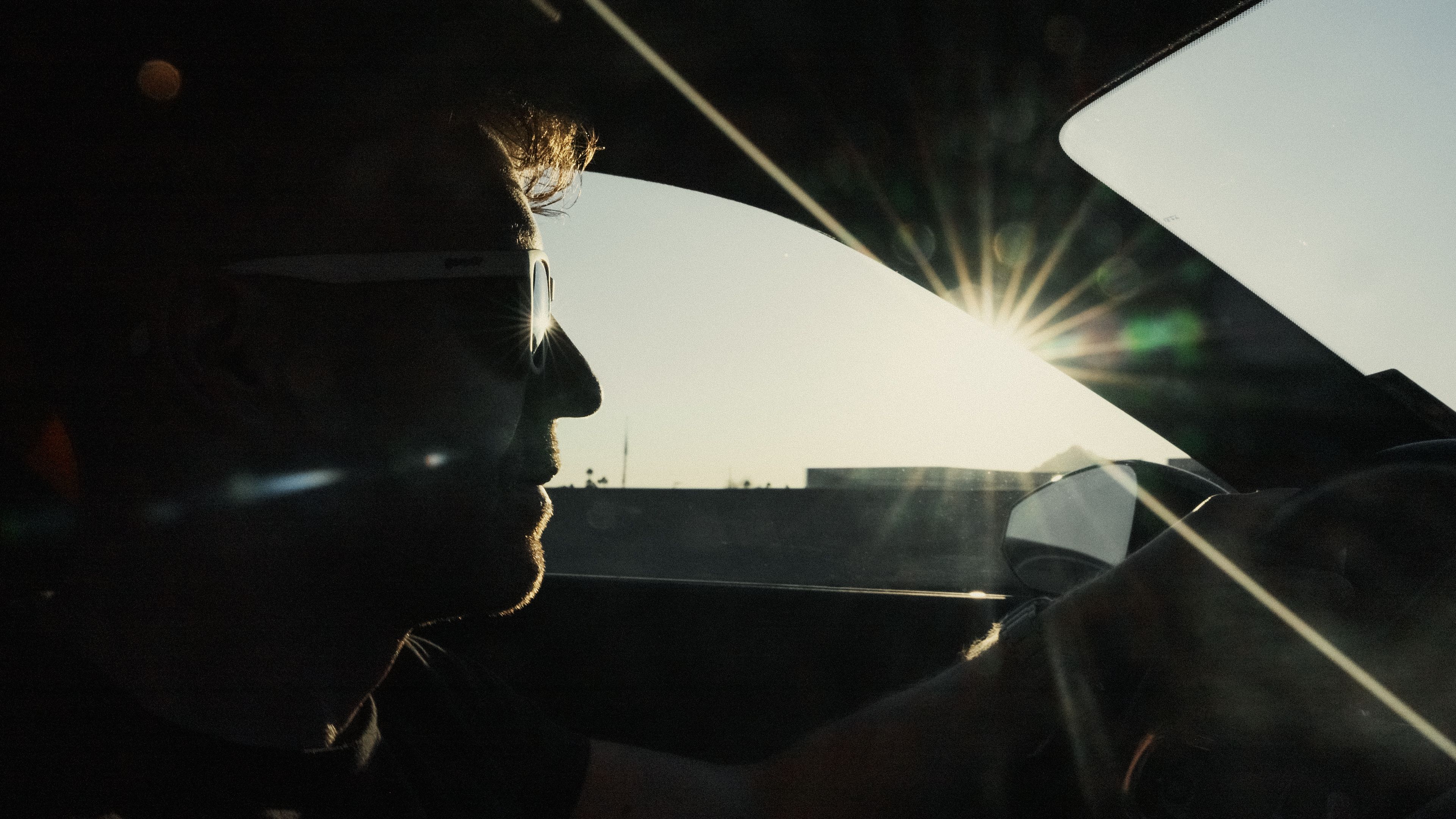 Face of man driving Polestar with sun shining through window