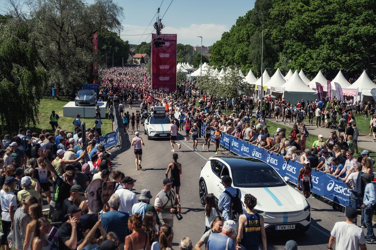 Polestar 3 och Polestar 4 kör längst en löparbana med människor som både springer och står vid sidan om