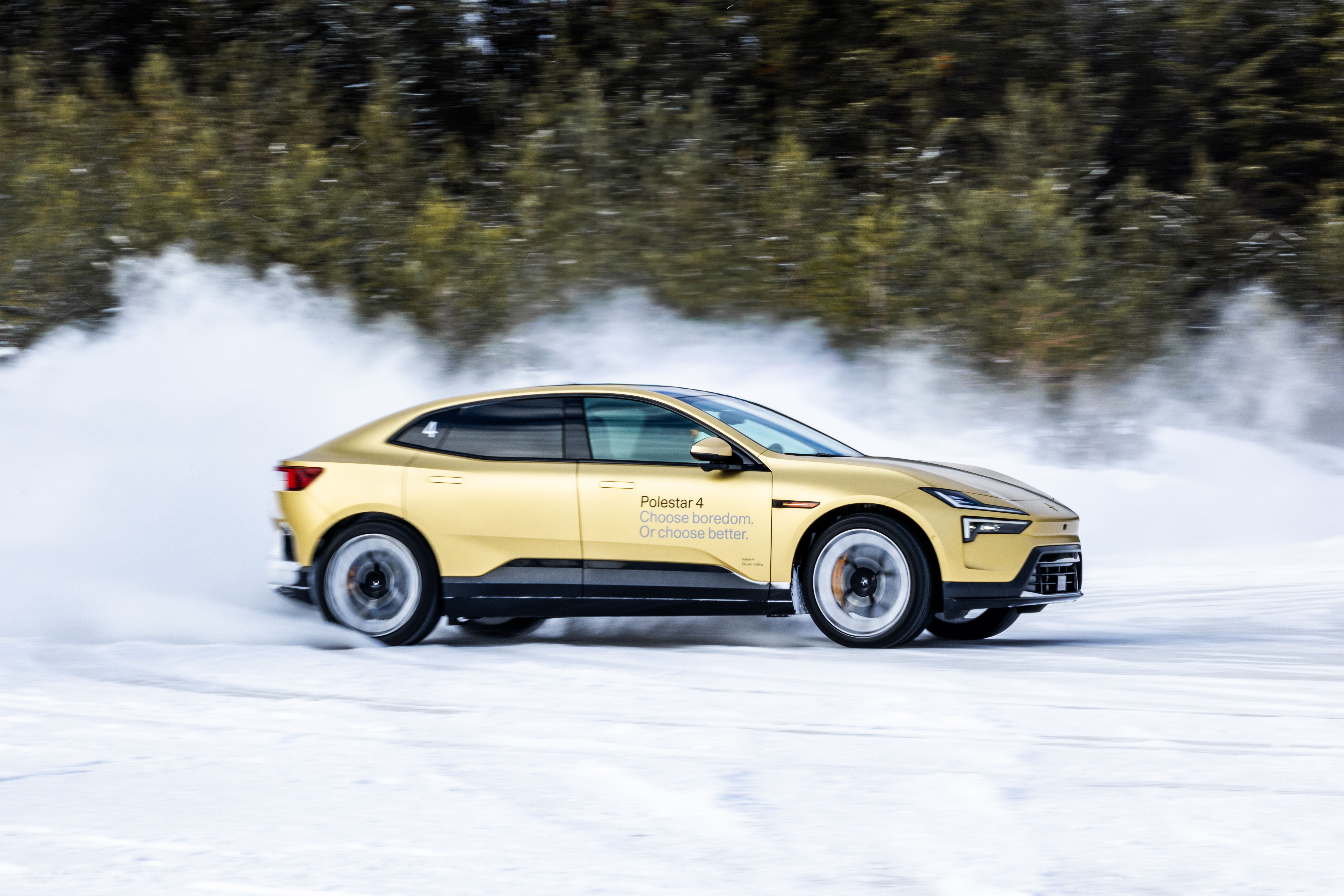 Polestar 4 driving on snow with snow spray, trees in background