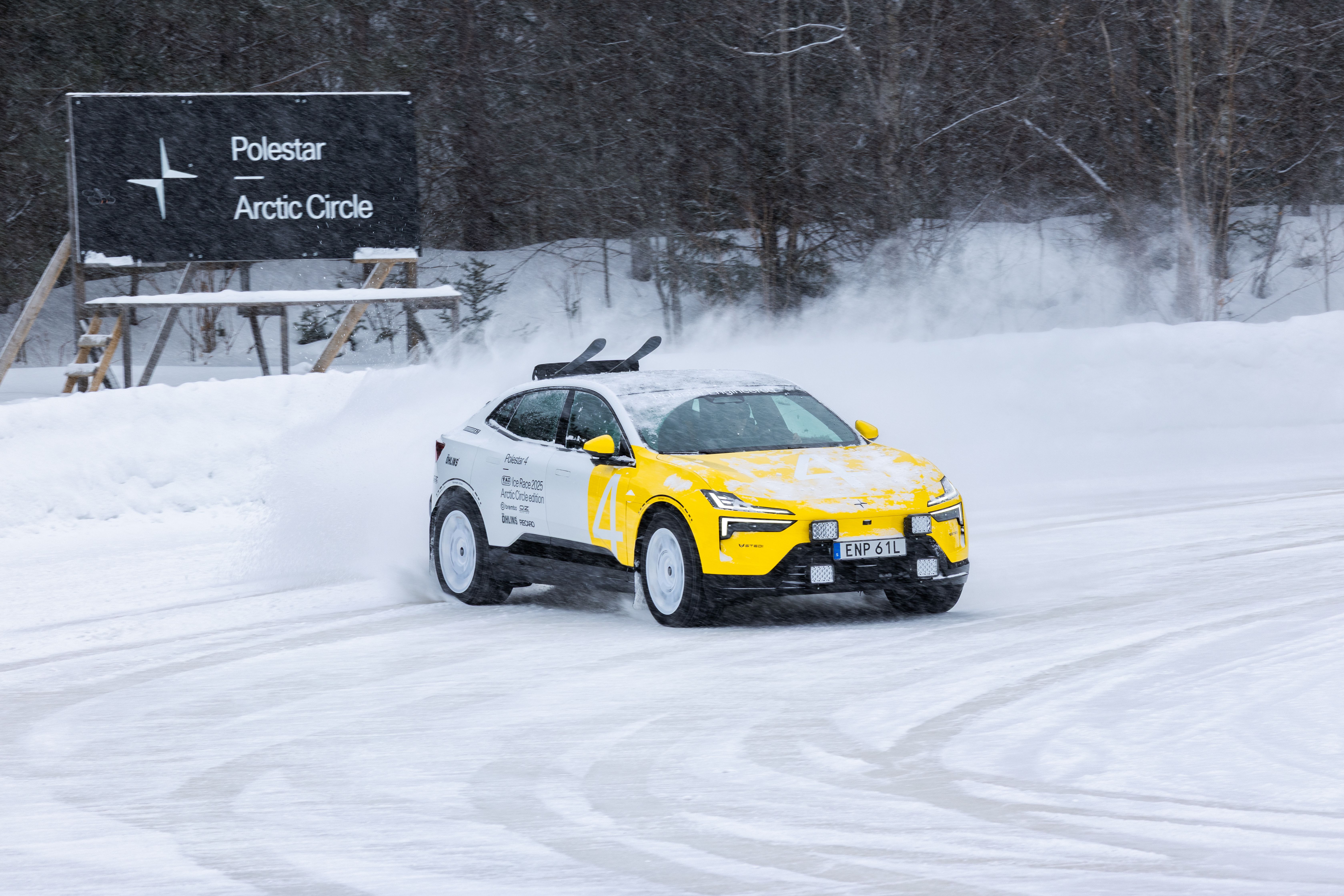 Polestar 4 on snow track, snow spray, sign reading “Polestar Arctic Circle” in background