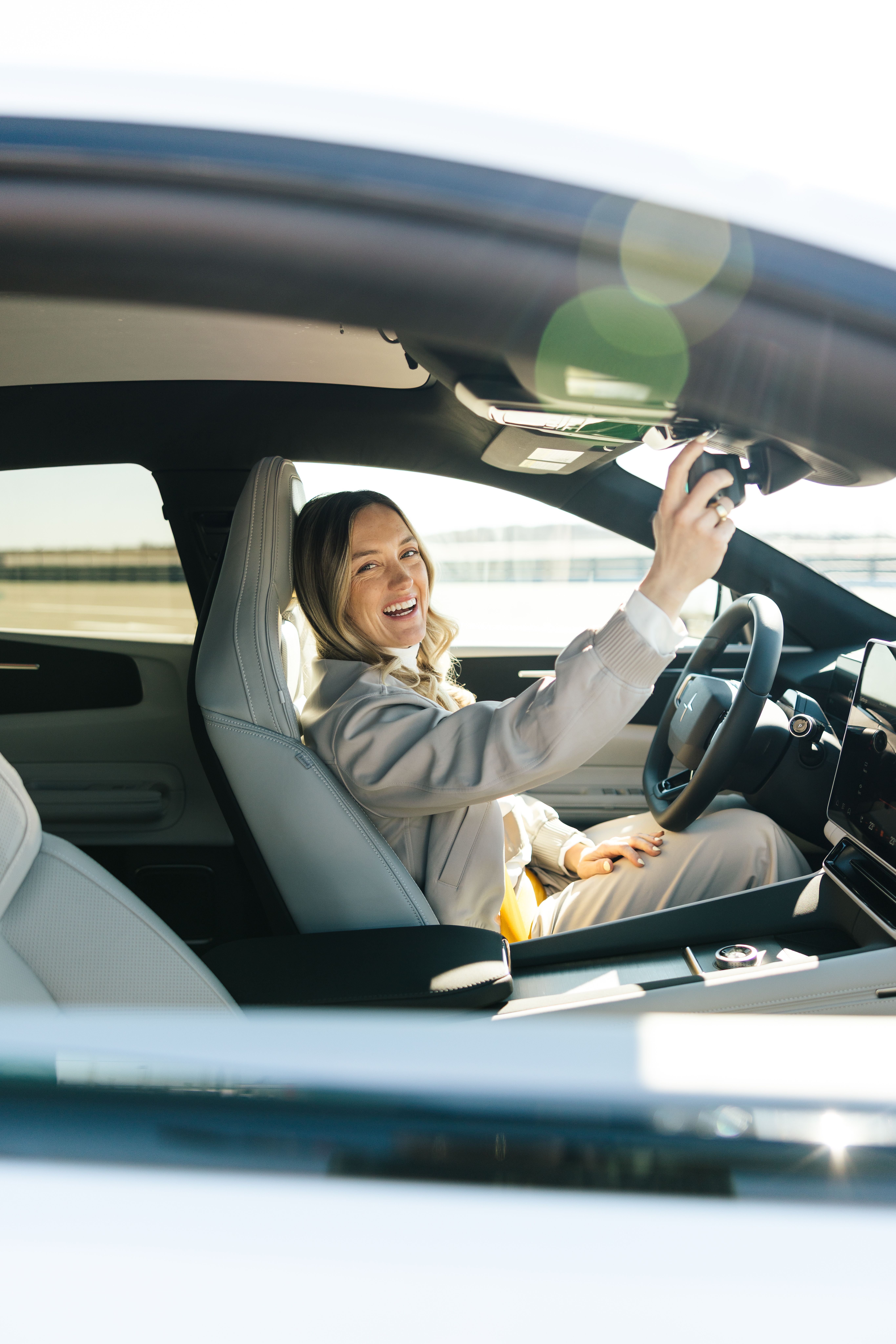 Person in car adjusting rearview mirror