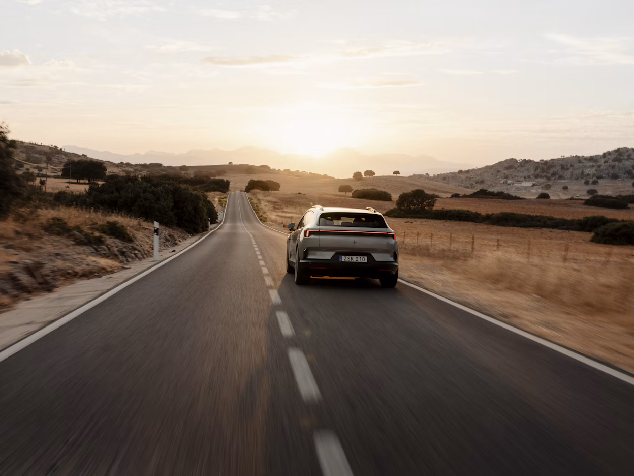 Polestar 4 SUV driving down country road at sunset