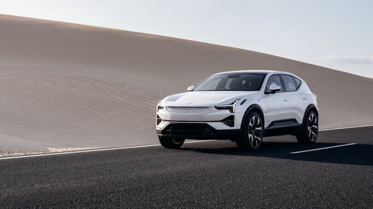 White Polestar 3 driving on a road with desert in the background.
