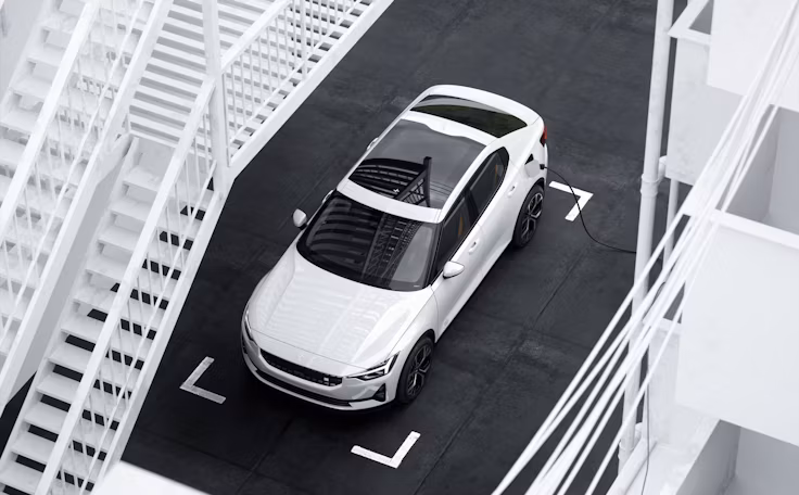 Polestar 2 en couleur Snow sur un parking noir en vue aérienne inclinée