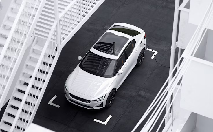 Polestar 2 in Snow auf schwarzem Parkplatz aus schräger Vogelperspektive