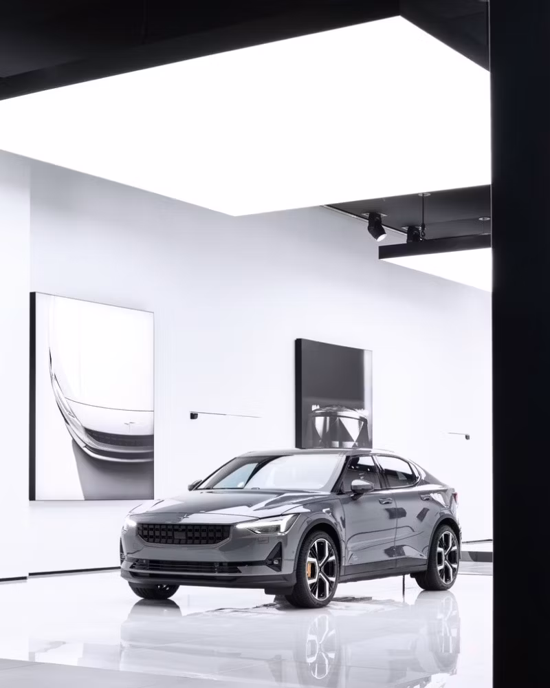 Polestar car displayed in a modern showroom with white walls and large ceiling lights.
