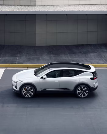 Polestar car parked on a paved surface with a modern building in the background.