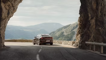 Polestar 2 driving on a road with mountainview