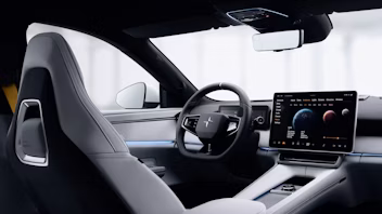 Interior of Polestar car showing steering wheel, touchscreen display, and seats.