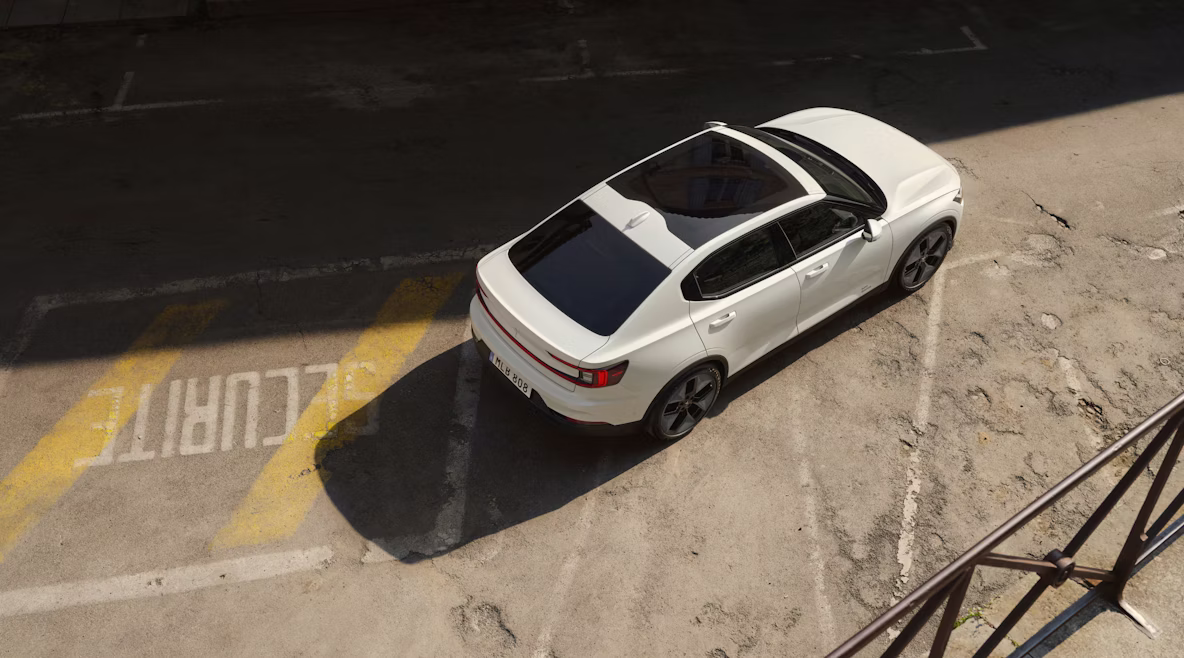 Polestar 2 staat op een parkeerplaats met vreemde belettering en versleten opschriften.