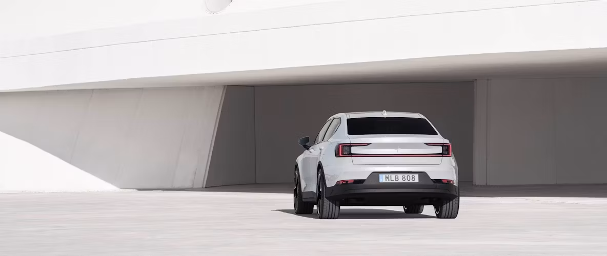 La Polestar 2 de couleur Snow, vu de derrière devant un bâtiment.