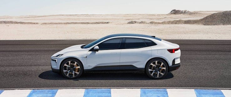 White Polestar 4 driving on a road with desert in the background.