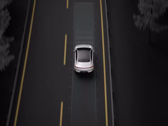 A top down view of Polestar 4 in Snow colour driving on a motorway with yellow lane markings