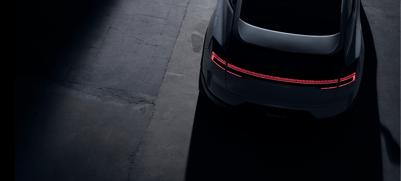 Rear view of Polestar 4 with illuminated taillights in a dimly lit space.