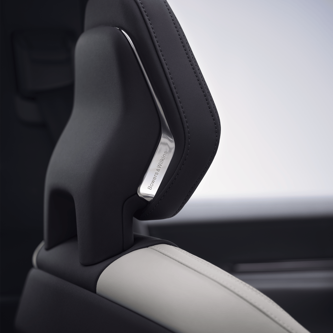 A close up view of Polestar 3’s front seat headrest with the Bowers & Wilkins metal logo.