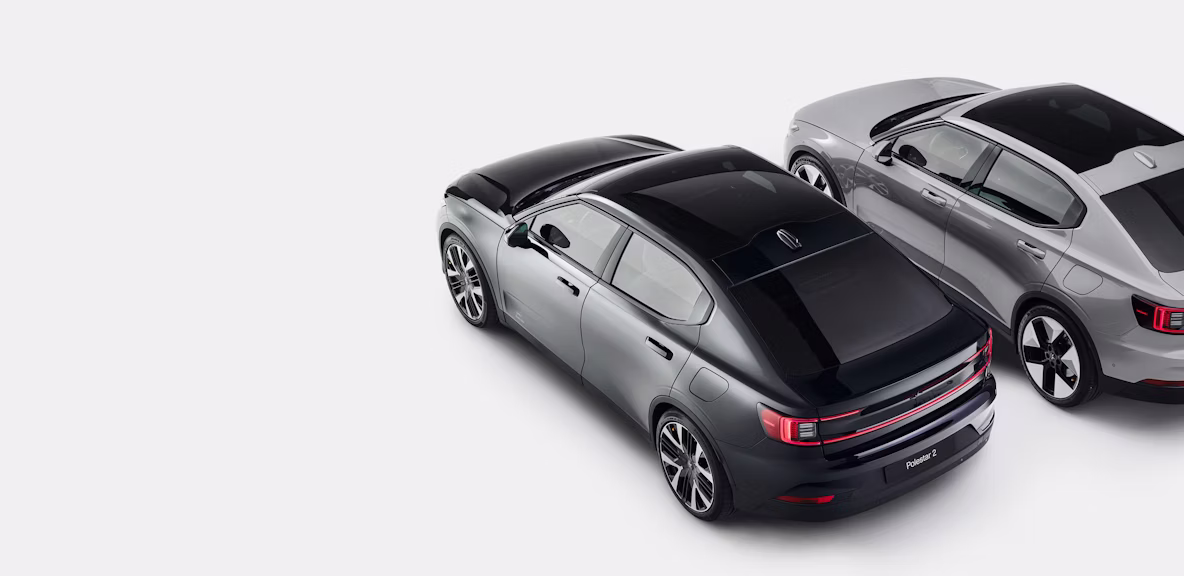 A downward view of a Polestar 2 in dark blue and another in grey standing side by side.