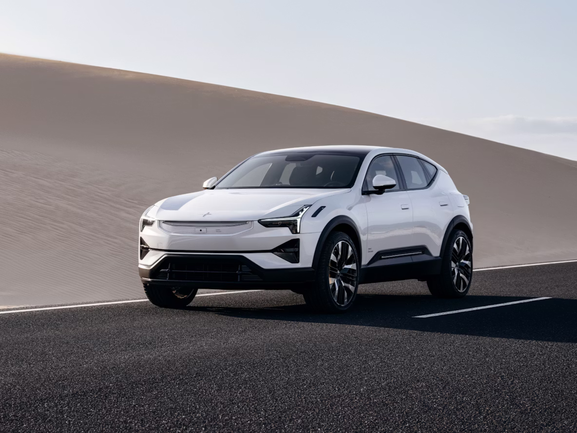 White Polestar 3 driving on a road with desert in the background.