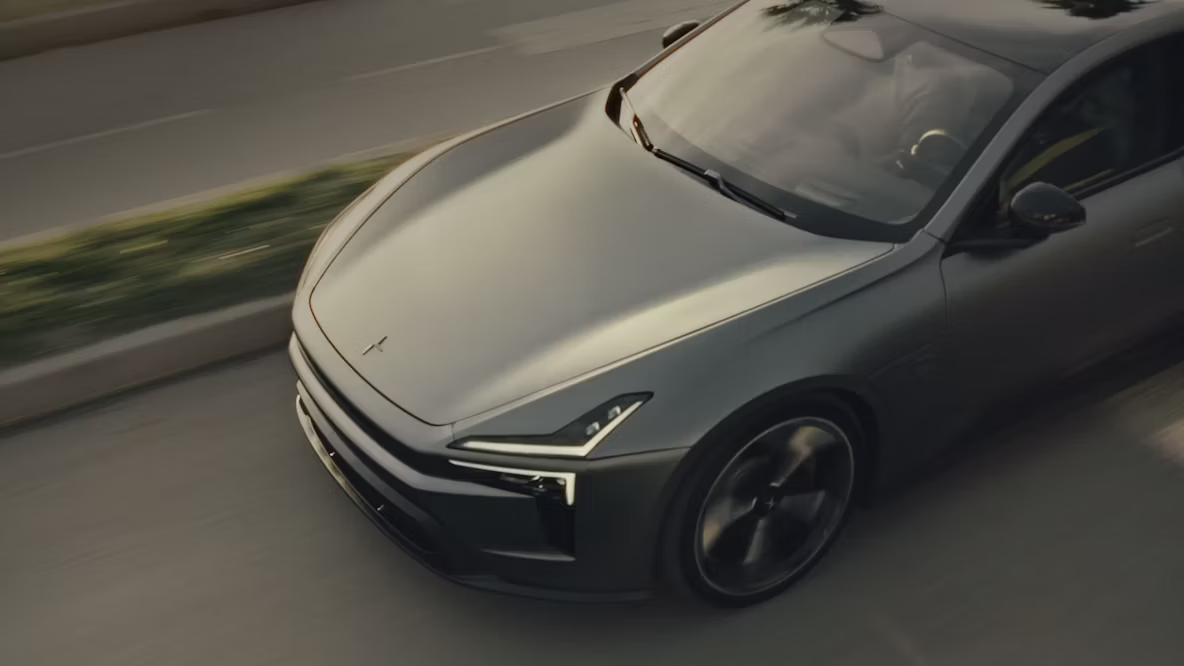 Polestar 5 car driving on a road with greenery in the median.