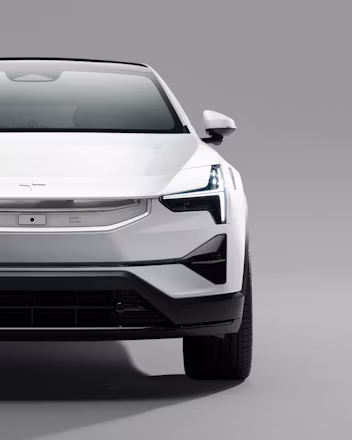 Front view of a white Polestar car against a gray background.