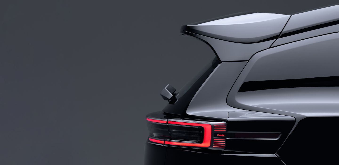 Rear view of Polestar 3 showing taillight and roof spoiler against a dark background.