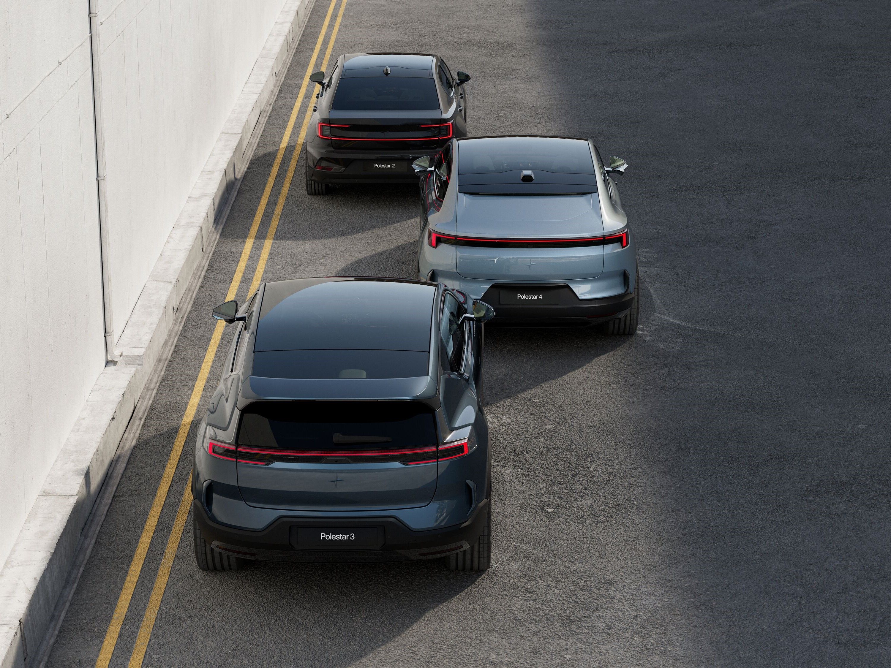 Polestar 2,3 and 4 driving on asphalt, seen from behind