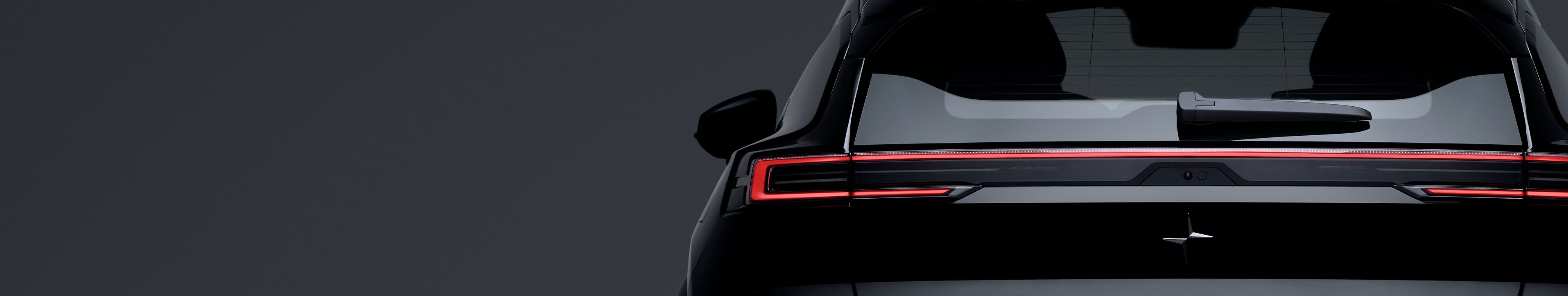 Rear view of Polestar 3 with illuminated tail lights and rear window wiper.