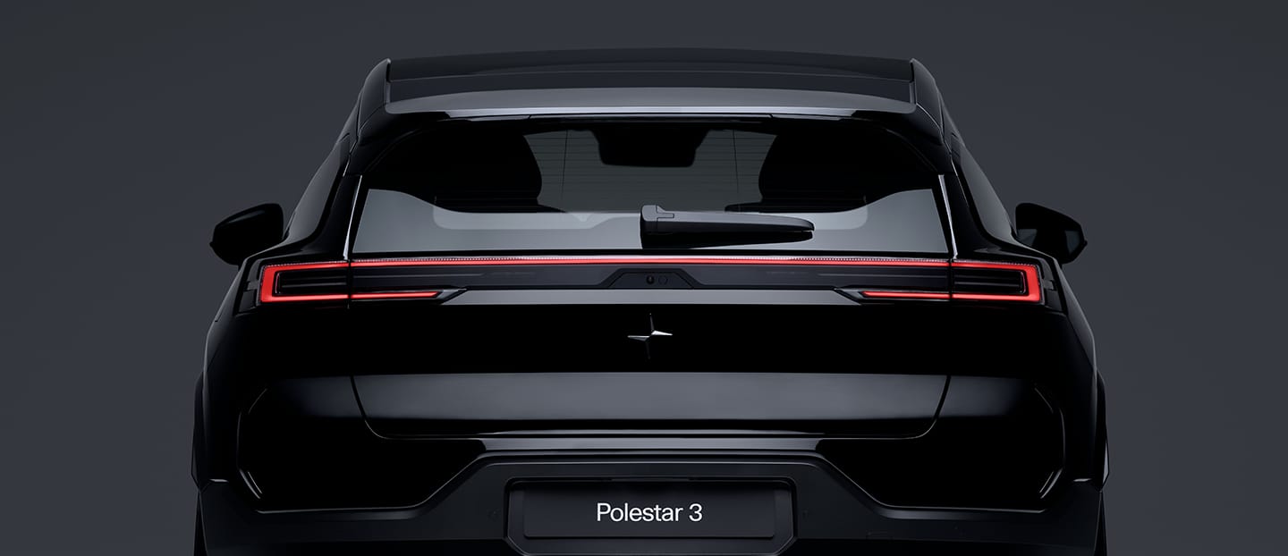 Rückansicht des Polestar 3 mit eingeschalteten Rückleuchten und Heckscheibenwischer vor dunklem Hintergrund.