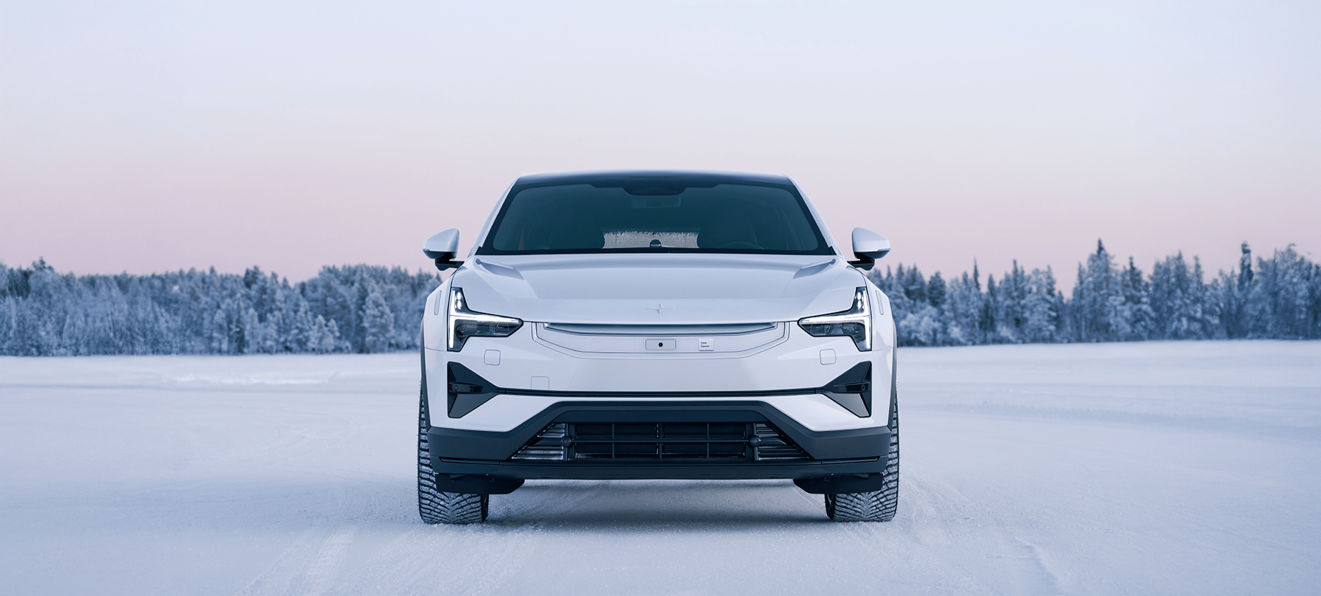 Voorkant van de Polestar 3 in een besneeuwd landschap.