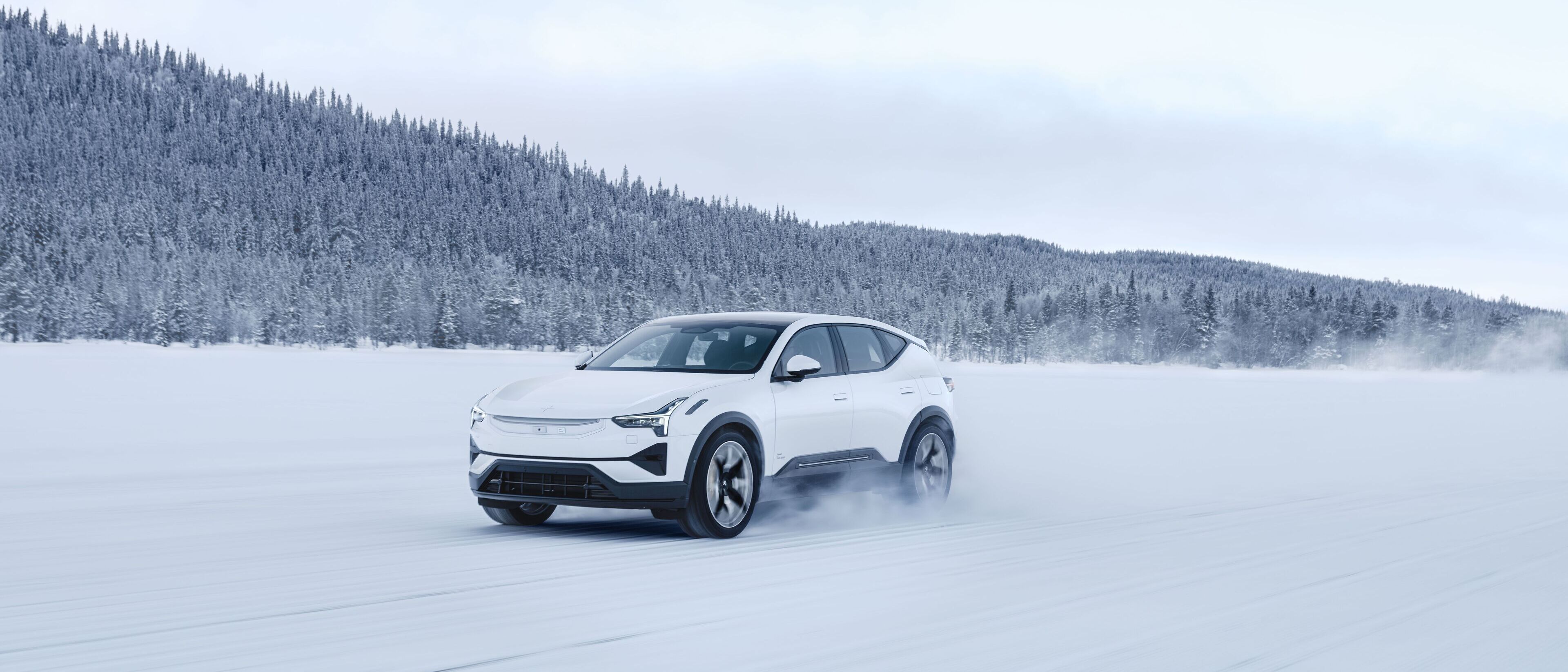 Polestar 3 nel colore Snow, vista di sbieco da davanti su un campo innevato.