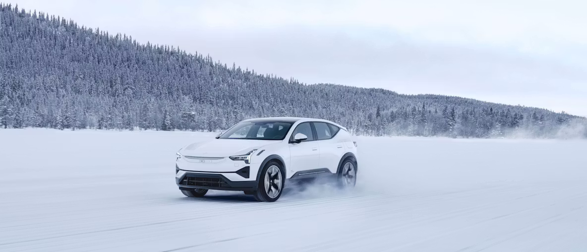 Polestar 3 nel colore Snow, vista di sbieco da davanti su un campo innevato.