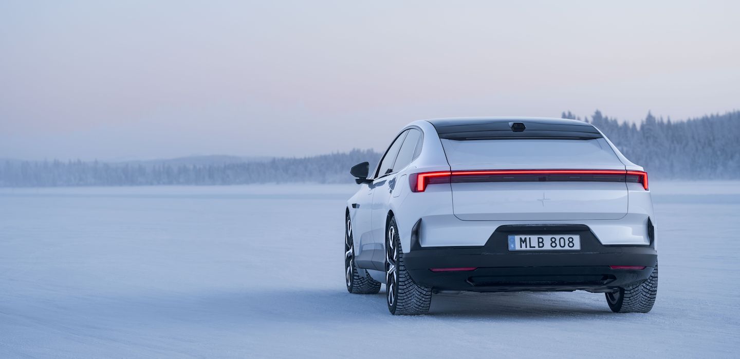 Polestar 4 car on snowy terrain with trees in the background under a pale sky.
